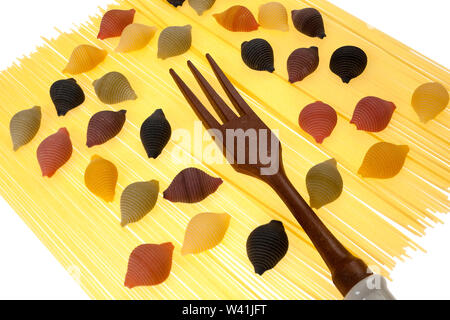 Fünf Farbe shell Pasta über Spaghetti und Holz- Gabel, auf weißem Hintergrund Stockfoto