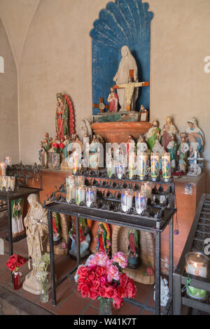 Die Kapelle Unserer Lieben Frau von Guadalupe zu ändern mit verschiedenen heiligen Statuen und Kerzen an der Mission San Xavier del Bac, Tucson, Arizona, USA gewidmet. Stockfoto
