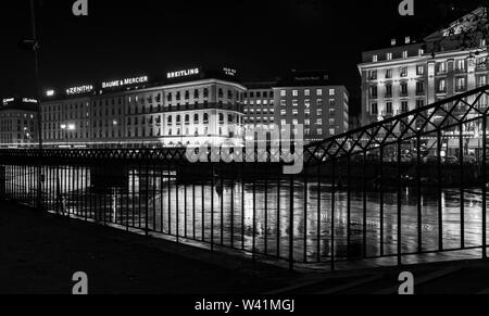 Genf, Schweiz - 24. November 2016: Nacht schwarz und weiß Stadtbild mit beleuchteten Fassaden und Spiegelungen in Rhone Wasser. Geneva City ce Stockfoto