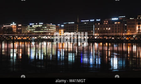 Genf, Schweiz - 24. November 2016: Nacht Panoramablick auf das Stadtbild mit bunten beleuchtete Fassaden und Spiegelungen in Rhone Wasser. Stadt Genf Stockfoto