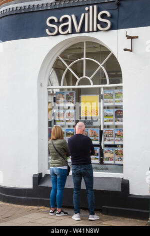 Ein Paar schaut in das Fenster von Savills Immobilienmaklern In Henley-on-Thames Stockfoto