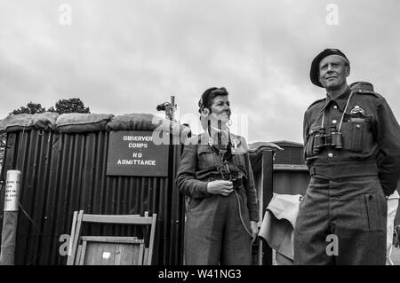 Nachbildung des Beobachterkorps im Zweiten Weltkrieg. Männliche und weibliche Reenactoren im Kriegskostüm mit Telefonkommunikation. Schwarzweiß. Blitz ARP Stockfoto