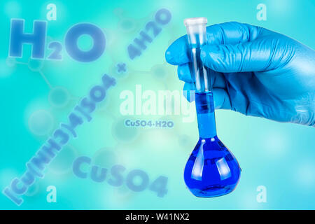 Die Hand im Handschuh hält das Reagenzglas. Stockfoto