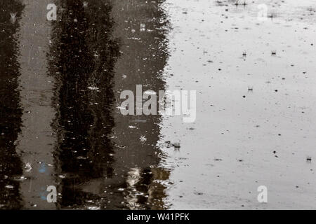 Regentropfen auf glänzenden nassen Flachbild asphalt Hintergrund mit selektiven Fokus. Stockfoto