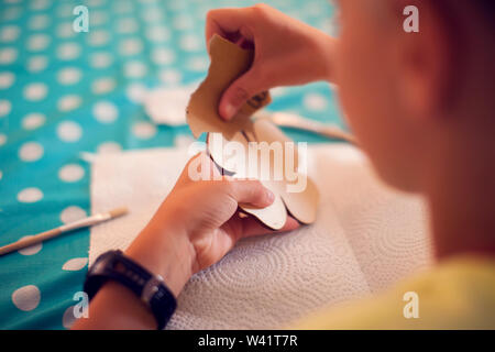 Kinder Hände machen Kunstwerke mit Holz und Farbe Handwerk. Workplace und Handwerk Decoupage Stockfoto