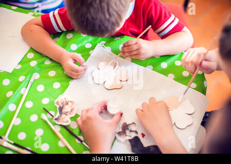 Kinder Hände machen Kunstwerke mit Holz und Farbe Handwerk. Workplace und Handwerk Decoupage Stockfoto