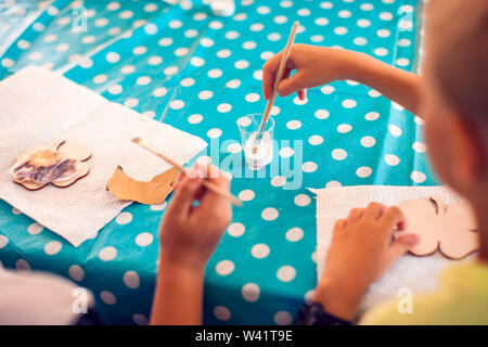 Kinder Hände machen Kunstwerke mit Holz und Farbe Handwerk. Workplace und Handwerk Decoupage Stockfoto