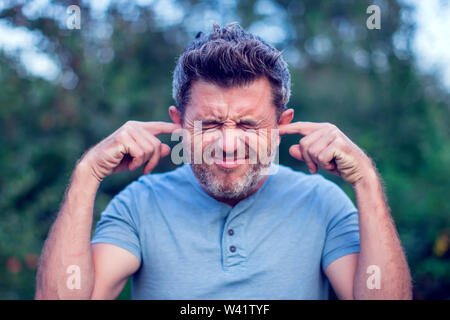 Portrait der junge Mann hält seine Hände über die Ohren nicht im Freien zu hören, Stockfoto