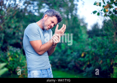 Menschen, Gesundheitswesen und Problem Konzept - unglückliche Menschen leiden von Palm Schmerz im Freien Stockfoto