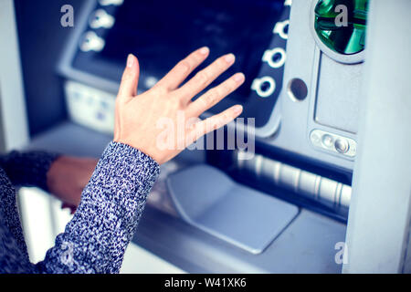 In der Nähe der weiblichen Hand Eingabe der PIN- Code ein, der auf ATM/Geldautomaten Tastatur, versteckt sie es mit der anderen Hand zu Sicherheitszwecken Stockfoto