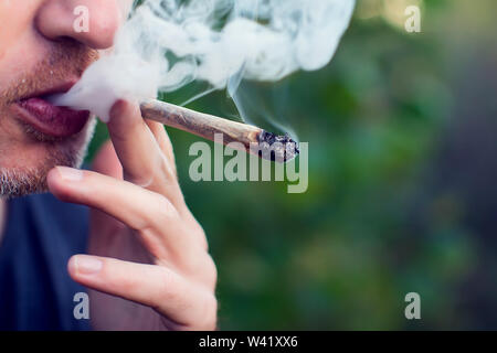 Mann raucht einen joint. Medizinische Verwendung von Marihuana und Legalisierung des Cannabis, leichte Drogen Konzept Stockfoto