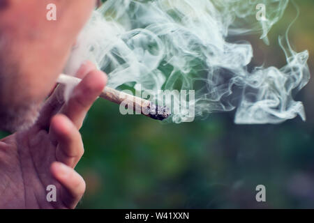 Mann raucht einen joint. Medizinische Verwendung von Marihuana und Legalisierung des Cannabis, leichte Drogen Konzept Stockfoto