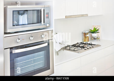 Teure Backofen Design mit Küchengeschirr, Herd nah am Zimmer, perfekte Blitz, am Abend Foto, auch einige Glasflaschen auf Pantry Tisch Stockfoto