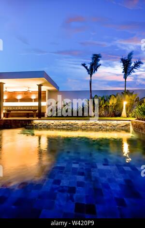 Luxus Pool und Garten mit Essbereich leuchtet mit Lichter in der Nacht Stockfoto