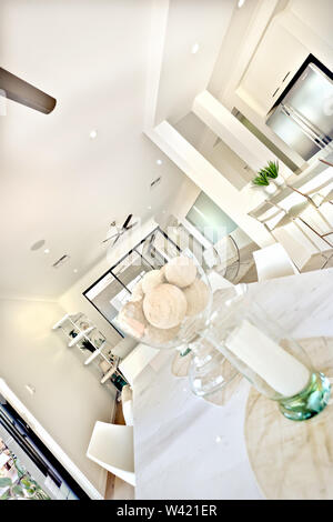 Moderner Esstisch Einrichtung mit weißen Wänden in der Küche mit einer Nahaufnahme einer Kerze und Glas Schüssel in die Wohnung Das Interieur Stockfoto