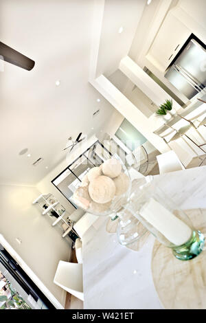 Moderner Esstisch Einrichtung mit weißen Wänden in der Küche mit einer Nahaufnahme einer Kerze und Glas Schüssel in die Wohnung Das Interieur Stockfoto