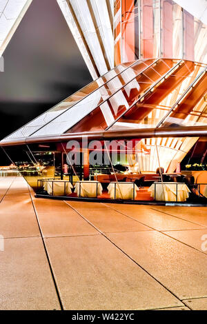 Sydney Opera House Bodenfliesen mit Blick auf die Stadt durch die Glaswände um den Bereich unter dem weißen Dach und Innenbeleuchtung Stockfoto
