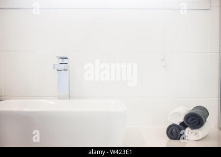Ein Blick auf ein Waschbecken und aufgerollten Handtüchern in Schwarz und Weiß Stockfoto