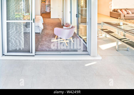 Modernes Haus oder Hotel Front mit eine Tür in ein Schlafzimmer mit Stühlen und Schrank geöffnet. hohen Winkel Foto anzeigen Stockfoto