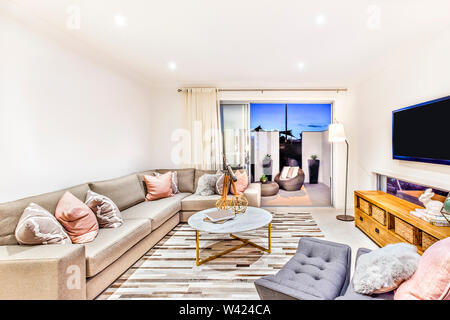 Luxuriöses Wohnzimmer mit Sofas und Kissen neben dem Eingang gibt es einen runden Tisch Mitte der Halle einschließlich der phantastischen Elemente neben dem d geöffnet Stockfoto