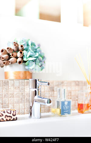 Silber mit aromatischen Duft Diffusor Flasche in ein modernes Bad mit Stöcken tippen Sie es neben Fancy flower Vase in der Nähe von an die Wand mit Fliesen Stockfoto