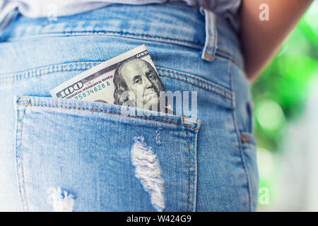 US-Dollar in die hintere Jeans-Tasche Stockfoto