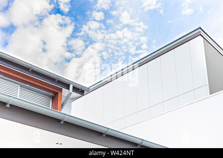 Moderne Villa high Angle Shot mit Holz- Fenster und blauer Himmel mit weißen Wolken, es ist ein Abflussrohr Stockfoto