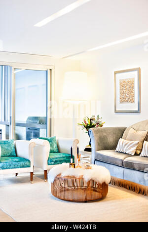 Wohnzimmer mit Sofas und hölzernen Stock, Tisch, inklusive Kerzen und Düfte auf der Wolle Teppich, die Tabelle wird in Runden Holz- net auf der gemacht Stockfoto