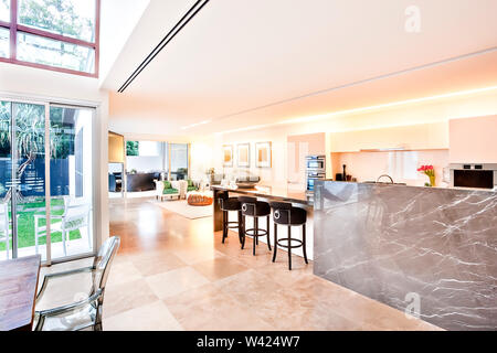 Haus im Innen- und Außenbereich einschließlich Küche und Wohnzimmer gibt es einen Garten können durch die Glastür gesehen werden, die glänzenden Zähler an der Wand und Stockfoto
