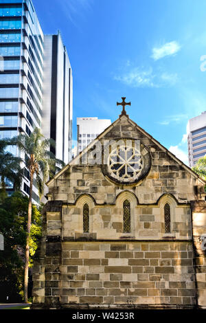 Vor einer alten Kirche aus der modernen städtischen Gebäude mit Sky einschließlich Bäume Stockfoto