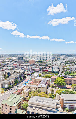 Blick auf die Stadt mit weißen Wolken und Sonne, natürliche Bäume in der Nähe der modernen Stadt Apartments auch Straßen, Business und Technologie Suche riesige Gebäude, Sky i Stockfoto