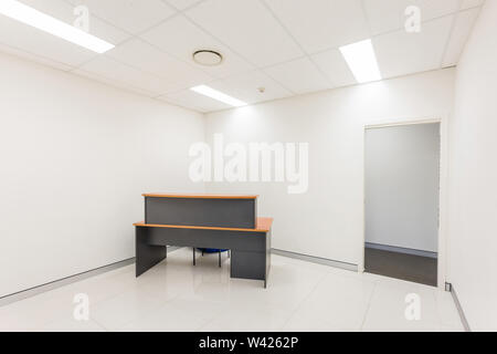 Die Schrulligen Holz Tisch mit einem orange oben in einem weißen Raum neben dem Zimmer. Stockfoto