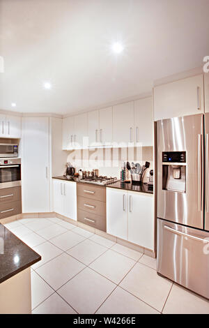 Vorderseite des Kochens Zimmer mit Schränken, Küche Design inklusive Ausstattung, neuesten Tools in der Nähe von Ofen, Spüle befestigt ist, Pantry, keramische Objekte auf t Stockfoto