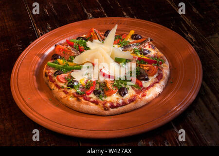 Käse und Salat Pizza mit Zwiebeln, Keramik Teller mit Essen auf Holztisch, Luxus Hotel oder Haus im Zimmer, Lichter und Farben sind perfekt. Stockfoto