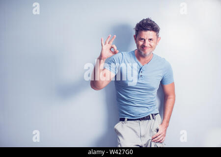 Mittleres Alter Mann lächelt breit Daumen hoch, Geste, die Kamera, den Ausdruck von wie und Genehmigung isoliert über blauer Hintergrund Stockfoto