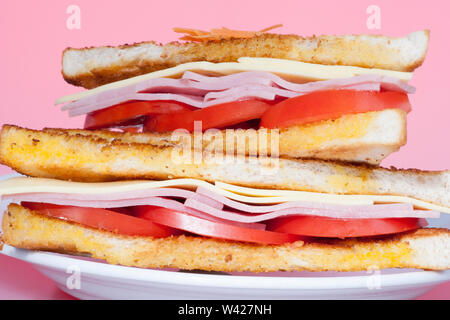 Leckere Sandwiches mit Tomaten und Käse, heißen Burger einschließlich Fleisch und Gemüse, sehr lecker aussehen, Hintergrund ist rosa Farbe, Esstisch eines Luxur Stockfoto