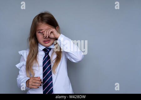 Kleine Schulmädchen, Gesicht, Portrait. Jugendliche betonte, erschrocken Kind verstecken, Tränen abwischen. Schüler, Student in Schuluniform. Zurück zu Schule, traurig, unglücklich junges Mädchen bereit für Klasse Stockfoto