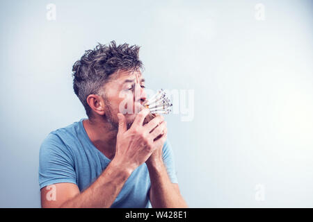 Junger Mann mit vielen Zigaretten in den Mund Stockfoto