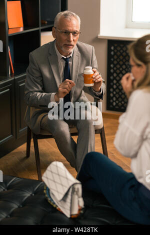 Professionelle Psychoanalytiker etwas zu erklären, seine weiblichen Patienten Stockfoto