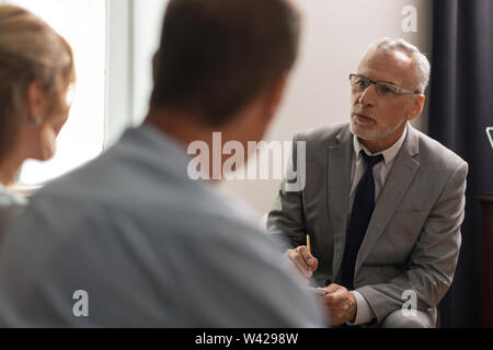 Ernsthafte konzentriert Psychoanalytiker seine Patienten psychische Gesundheit Bewertung Stockfoto