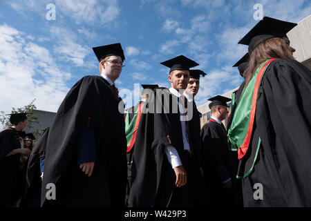 Höhere Bildung in Großbritannien - erfolgreiche Studenten an der Abschlussfeier in Aberystwyth University, nach ihrem Grad empfangen, tragen ihre traditionellen Kappen und Kleider. Juli 2019 Stockfoto