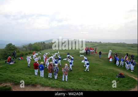 Morris Dancing n oben Painswick Beacon Sonnenaufgang am Tag zu zelebrieren. Stockfoto