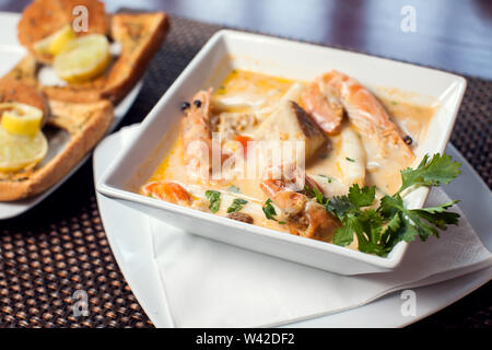 Meeresfrüchte creme Suppe mit Toast in weißer Teller auf dem Tisch. Stockfoto