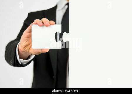 Geschäftsmann mit einem Stück des Puzzles stehen bereit, die zwei passende Formen zu einem Konzept der Problemlösung und Meeting business Cha anbringen Stockfoto