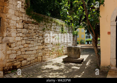 Blick auf eine Straße mit alter Steinmauer und Brunnen, Porec, Istrien, Kroatien Stockfoto