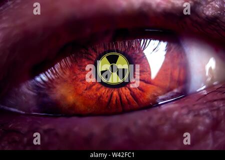 Close-up menschlichen Braunes Auge mit Strahlung Gefahrensymbol-Konzept Foto. Stockfoto