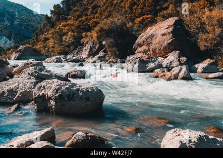 Ein Mann, der mit seinem Kanu Rafting auf einem Berg, Fluss Stockfoto