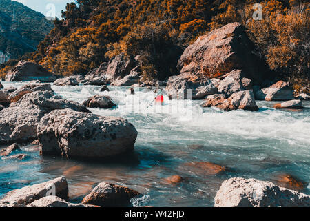 Ein Mann, der mit seinem Kanu Rafting auf einem Berg, Fluss Stockfoto