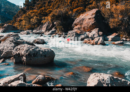 Ein Mann, der mit seinem Kanu Rafting auf einem Berg, Fluss Stockfoto