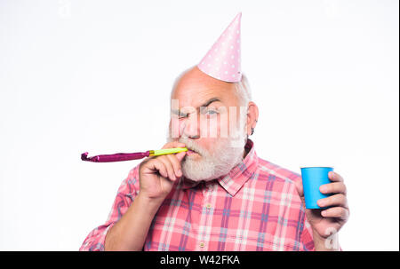 Ideen für Senioren Geburtstag feiern. Man bärtige Opa mit dem Geburtstag Cap und trinken Cup. Großvater Greis blasen party Pfeifen. Älter ist immer noch Spaß. Ältere Menschen. Geburtstag Konzept. Stockfoto